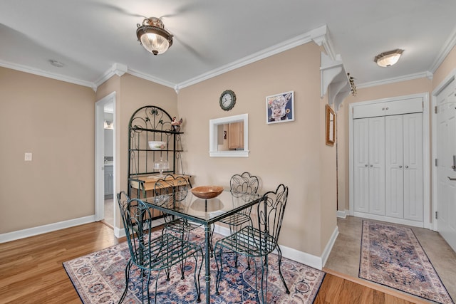 dining space with baseboards, crown molding, and wood finished floors