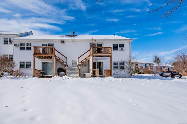 snow covered back of property featuring stairway