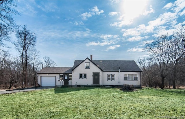 view of front of property with a garage, driveway, a chimney, and a front lawn