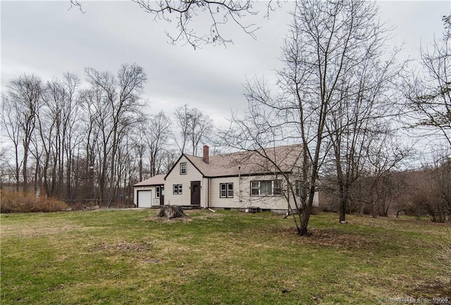 view of front of property featuring driveway, a garage, a chimney, and a front lawn