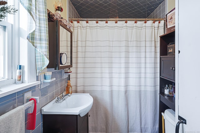 bathroom with decorative backsplash, tile walls, and vanity