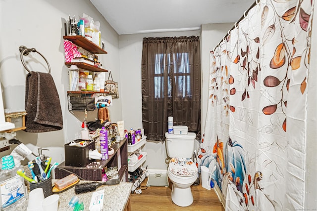 full bath with toilet, a shower with curtain, and wood finished floors