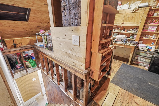 staircase with wood walls and wood finished floors