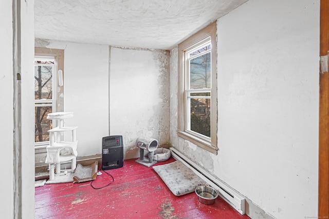 empty room featuring heating unit, a baseboard radiator, and a textured ceiling