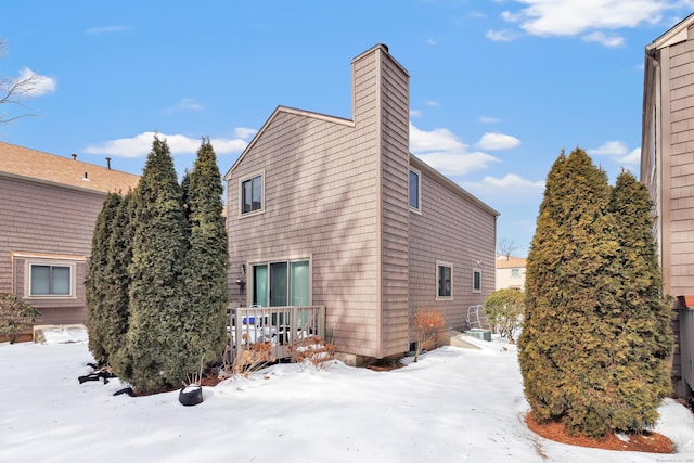 view of snowy exterior with a chimney