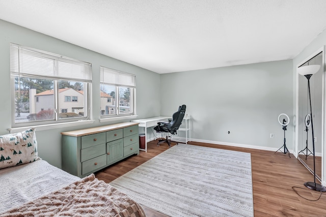 bedroom featuring dark wood-style flooring and baseboards