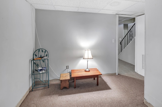 carpeted office featuring baseboards and a drop ceiling