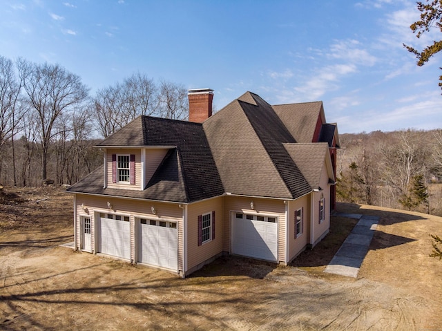 view of side of property with roof with shingles and a chimney