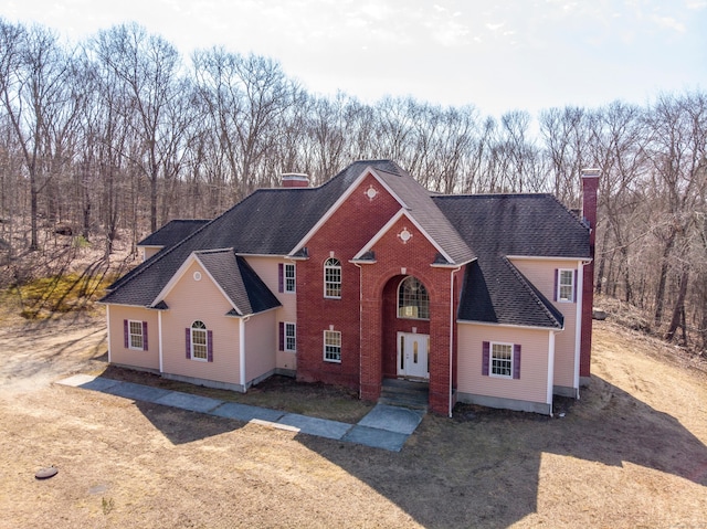 view of front of property with a chimney and a shingled roof