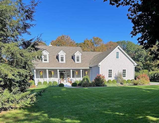 new england style home with covered porch and a front lawn