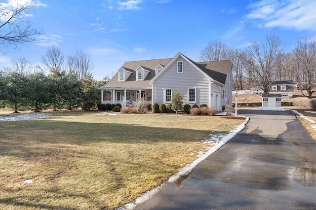 cape cod-style house with a garage, driveway, a porch, and a front yard