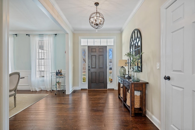 entryway featuring a chandelier, ornamental molding, dark wood finished floors, and baseboards