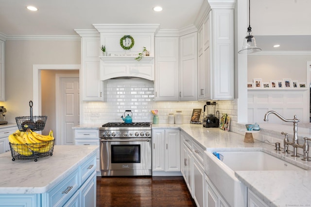 kitchen with pendant lighting, high end stainless steel range, white cabinetry, a sink, and light stone countertops