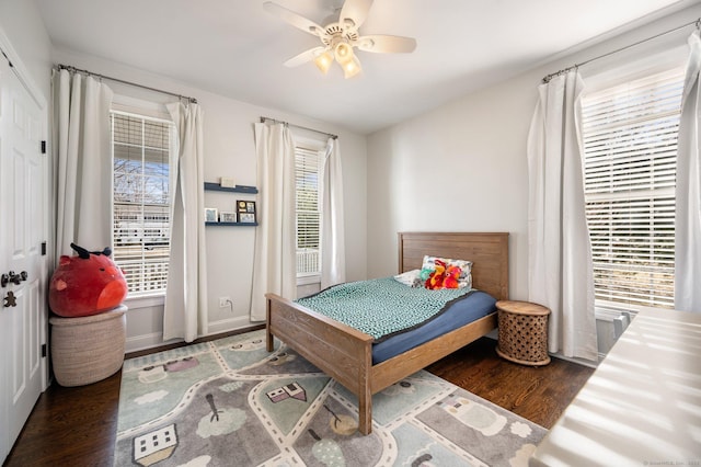 bedroom featuring dark wood-style floors, multiple windows, and ceiling fan