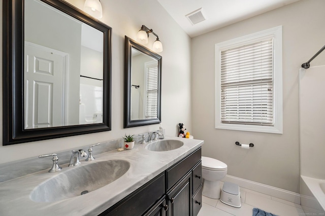 full bathroom with double vanity, a sink, toilet, and baseboards