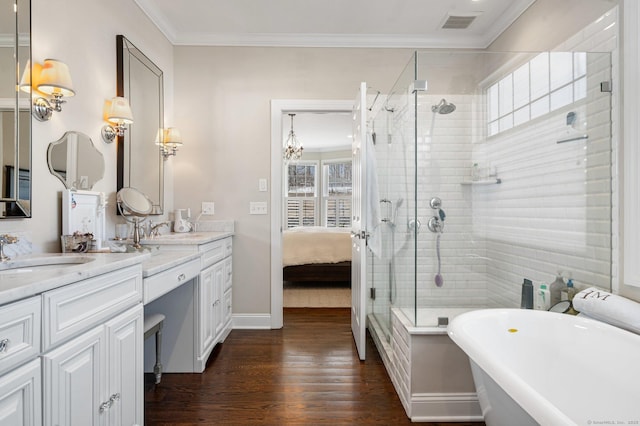 full bath featuring a wealth of natural light, crown molding, a freestanding bath, and a sink