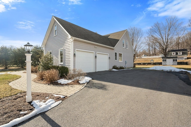 view of property exterior with driveway and a garage