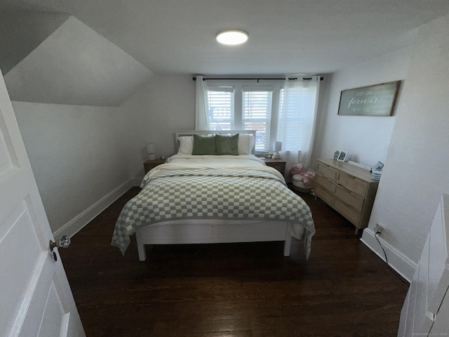 bedroom featuring lofted ceiling, baseboards, and dark wood finished floors