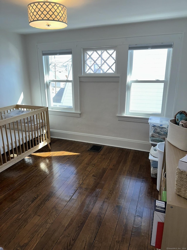 interior space featuring dark wood-style flooring, visible vents, and baseboards