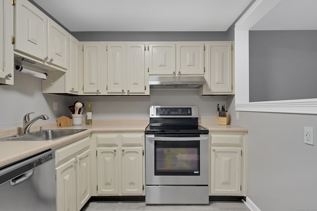 kitchen with stainless steel appliances, light countertops, white cabinetry, a sink, and under cabinet range hood