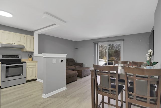 kitchen with stainless steel electric stove, light countertops, light wood-style flooring, under cabinet range hood, and baseboards