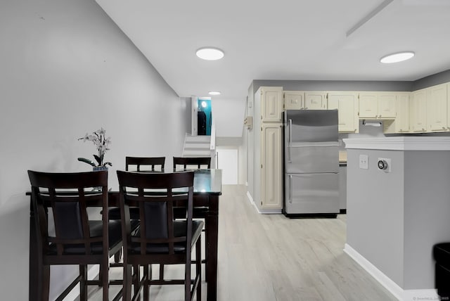 dining room featuring light wood-style flooring and baseboards