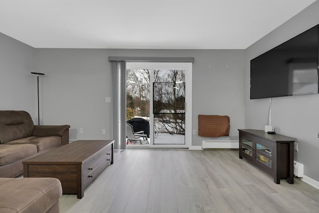 living area with light wood-type flooring, baseboards, and baseboard heating