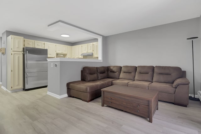 living area featuring light wood-style flooring and baseboards