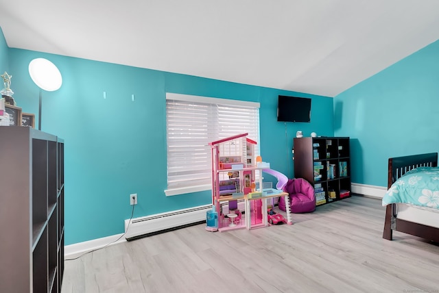 bedroom with a baseboard radiator, lofted ceiling, baseboards, and wood finished floors