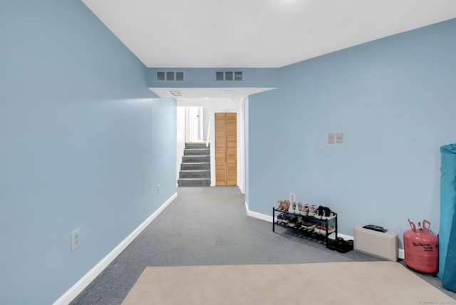 interior space with carpet floors, visible vents, baseboards, and stairs