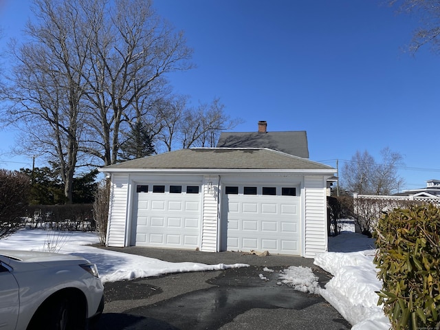 snow covered garage featuring a detached garage