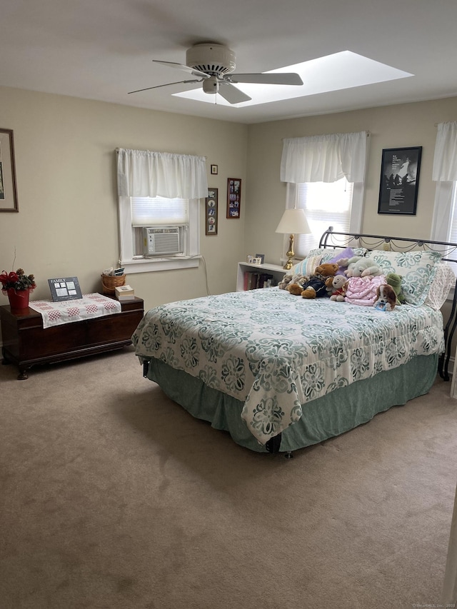 bedroom featuring a skylight, ceiling fan, cooling unit, and carpet flooring