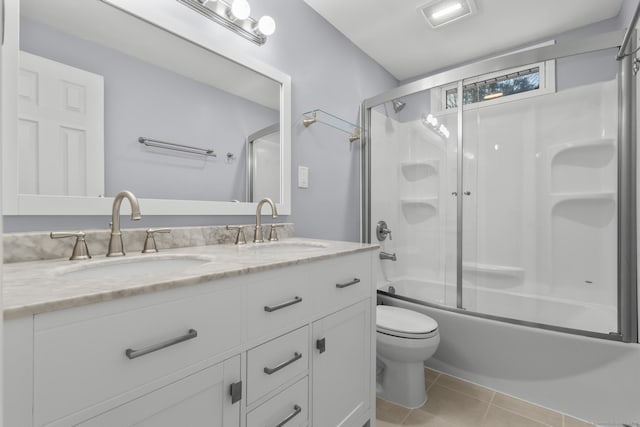 bathroom featuring double vanity, enclosed tub / shower combo, a sink, and tile patterned floors