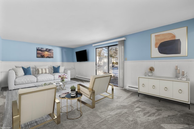 carpeted living room with a wainscoted wall and a baseboard heating unit