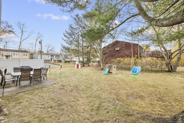 view of yard featuring a patio, a playground, fence, and a residential view