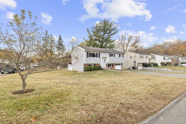 view of front of house with entry steps, driveway, an attached garage, and a front yard