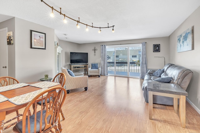 dining space with light wood-style flooring and baseboards