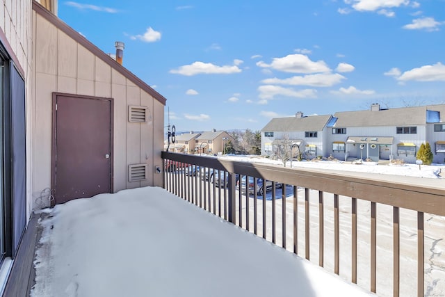 snow covered back of property with a residential view