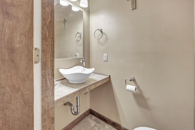 bathroom with baseboards and a sink