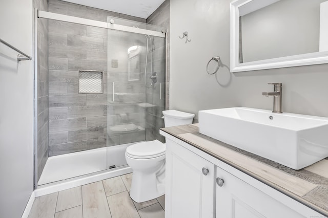 bathroom featuring a stall shower, vanity, and toilet