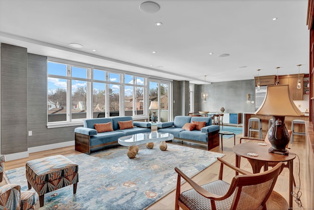 living area featuring recessed lighting, baseboards, and light wood finished floors