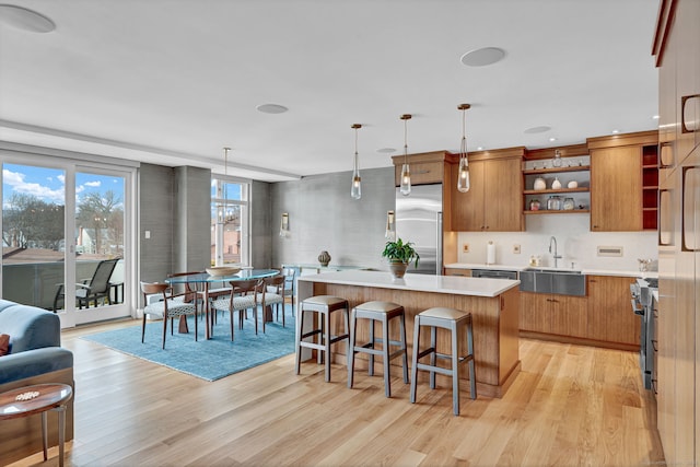 kitchen featuring open shelves, light countertops, light wood-style floors, a kitchen island, and high quality appliances