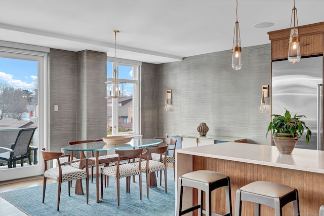 dining area with light wood finished floors and a notable chandelier