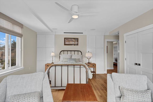 bedroom featuring ceiling fan, a closet, and light wood-style flooring