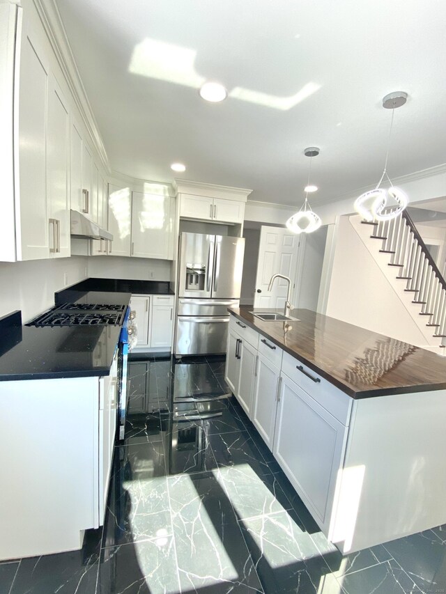 kitchen featuring marble finish floor, under cabinet range hood, white cabinets, stainless steel fridge with ice dispenser, and a sink