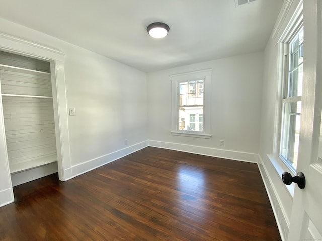 unfurnished bedroom featuring baseboards and dark wood-style floors