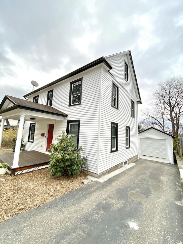 view of front of property with covered porch, driveway, an outbuilding, and a garage