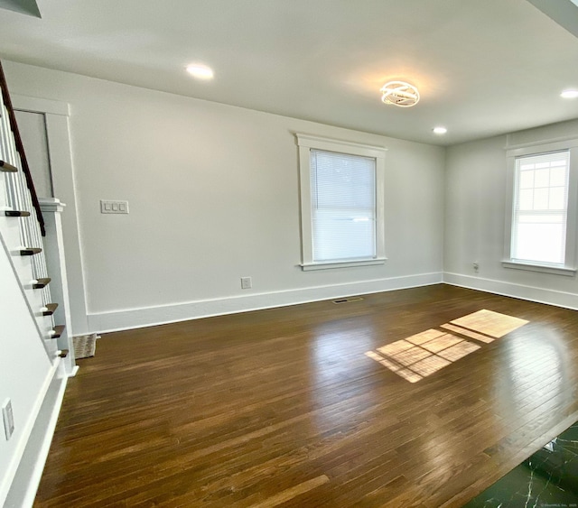 spare room with stairs, recessed lighting, baseboards, wood finished floors, and visible vents