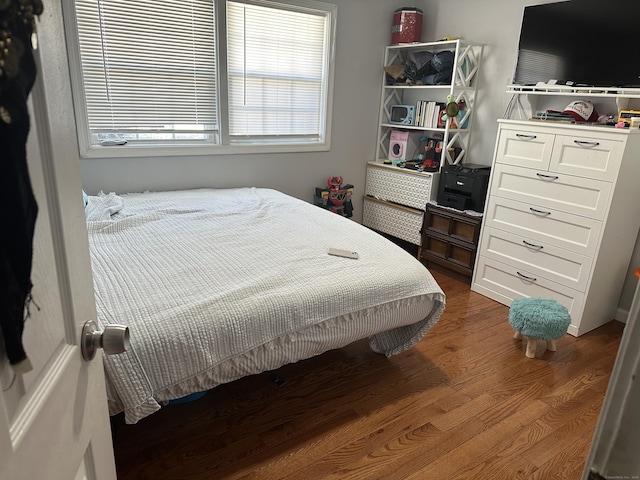 bedroom with dark wood-style flooring