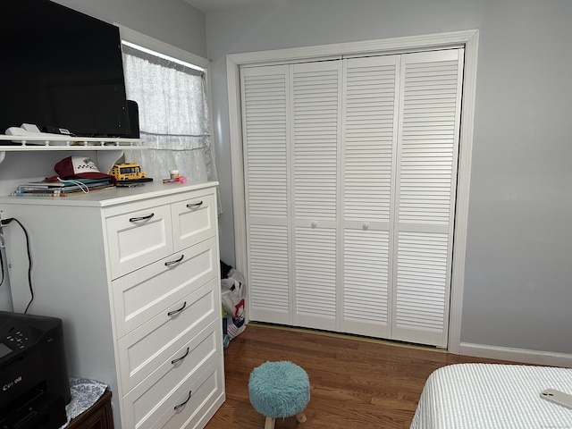 bedroom featuring a closet and dark wood-style flooring